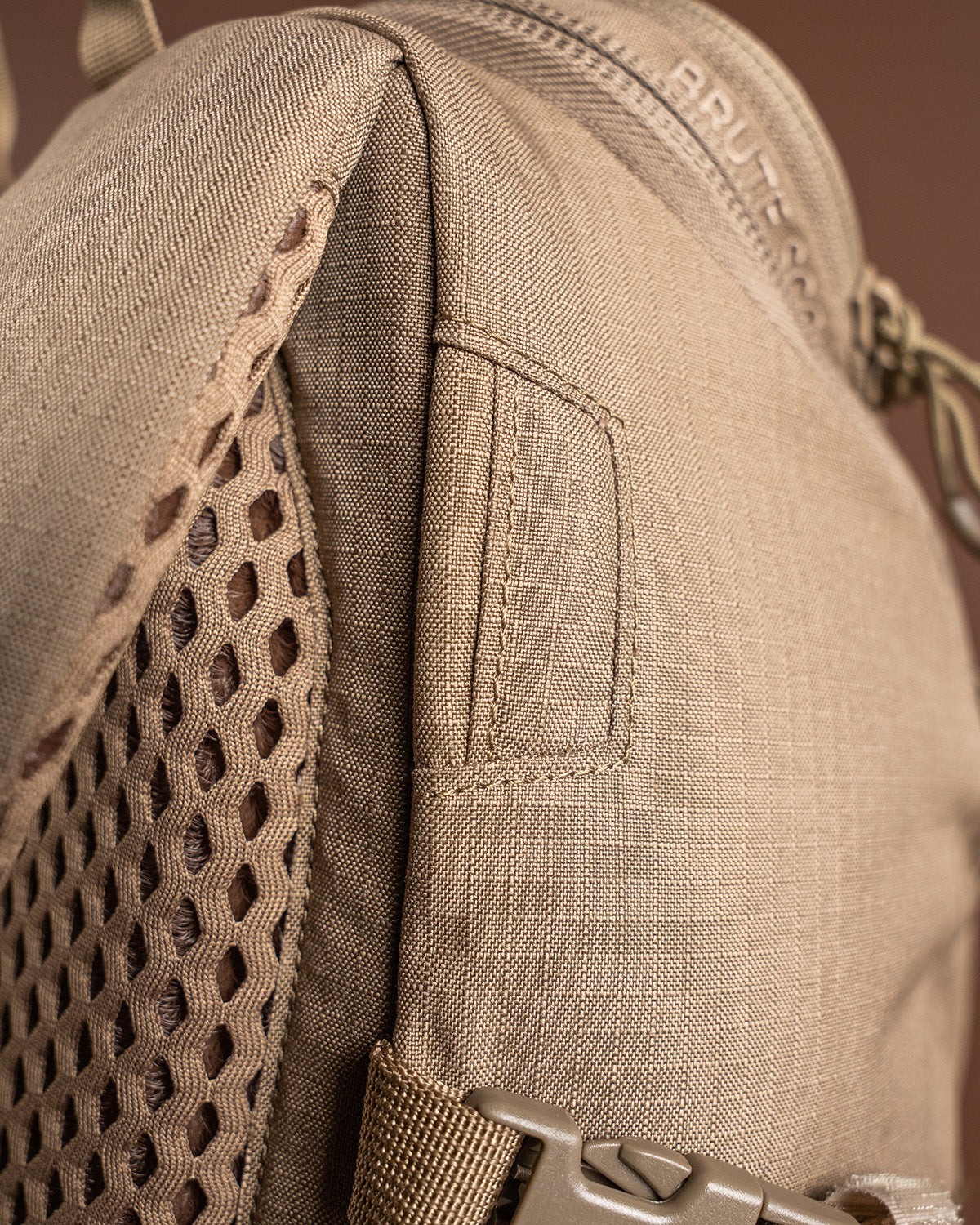 Die Nahaufnahme des EBERLESTOCK Brute Scout zeigt detaillierte Nähte, eine Seitenwand aus Mesh, einen Reißverschluss, ein strapazierfähiges Gewebe mit Gittermuster und eine robuste Kunststoffschnalle - perfekt für Fans dieses kompakten Rucksacks.