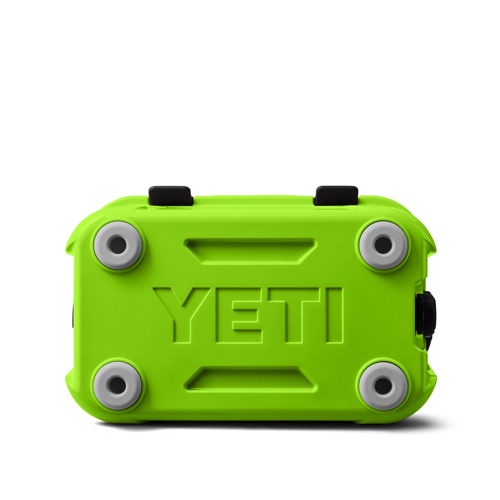 Eine leuchtend grüne YETI® Kühlbox Roadie 15 - Venom wird von unten gezeigt, mit vier runden grauen Füßen und einem zentralen geprägten YETI-Logo, das das robuste Outdoor-Design dieser kompakten Kühlbox hervorhebt.