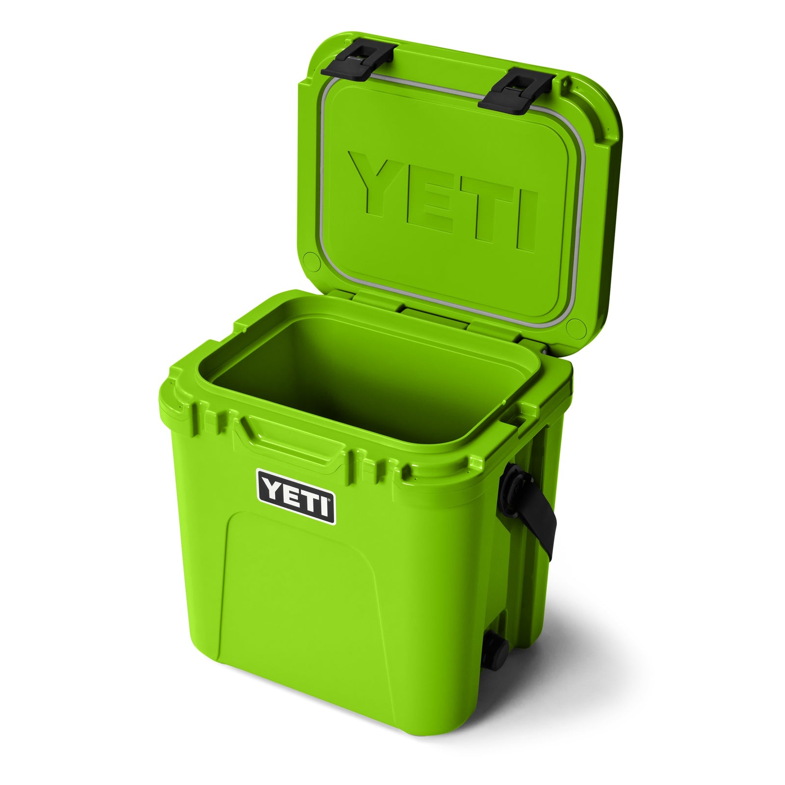 Die YETI® Kühlbox Roadie 24 - Venom ist geöffnet auf weißem Hintergrund abgebildet und zeigt ihren leeren isolierten Innenraum und den schwarzen Griff. Das YETI-Logo ist auf der Vorderseite und der Innenseite des Deckels dieser robusten, leuchtend grünen Kühlbox zu sehen.