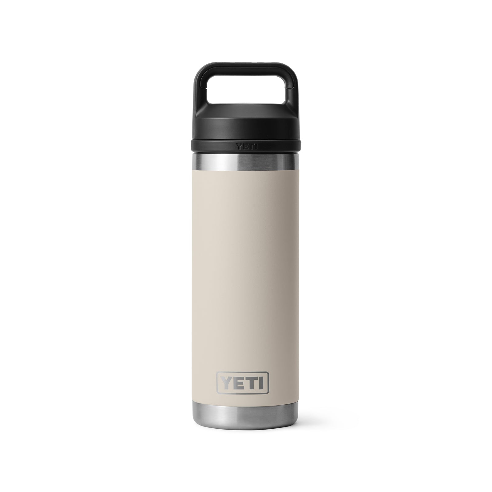 Die YETI® Flasche Rambler 18 Oz in Cape Taupe, aus Edelstahl mit schwarzem Griffdeckel und doppelwandiger Vakuumisolierung, zeigt das YETI-Logo in Bodennähe und steht aufrecht auf weißem Grund.