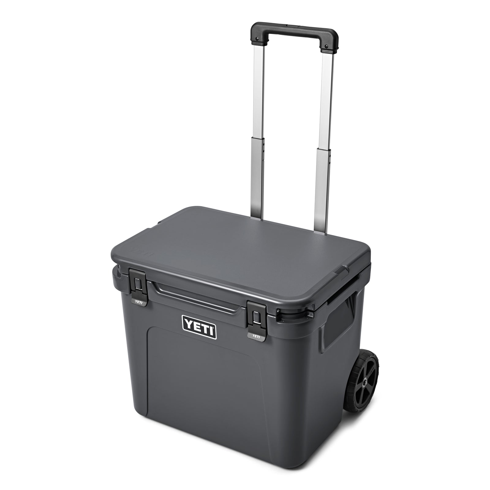Die YETI® Kühlbox Roadie 60 - Charcoal ist eine tragbare Kühlbox mit schwarzen Rädern, einem Teleskopgriff, sicheren Frontverschlüssen und dem YETI-Logo an der Seite - ideal für den Einsatz im Freien.
