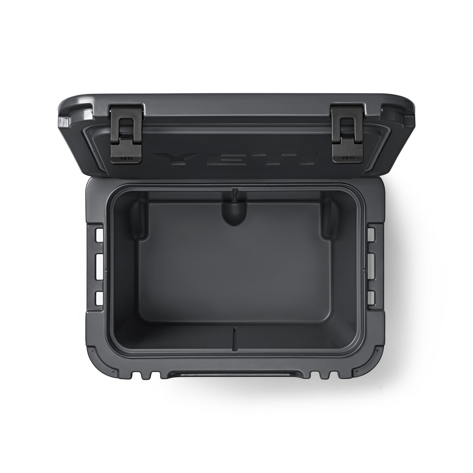 Draufsicht auf eine geöffnete, leere YETI® Kühlbox Roadie 60 - Charcoal mit stabilen Seitenverschlüssen und dickem Isolierdeckel - ihr geräumiger Innenraum macht sie zur perfekten Kühlbox mit Rollen für Ihr nächstes Abenteuer.