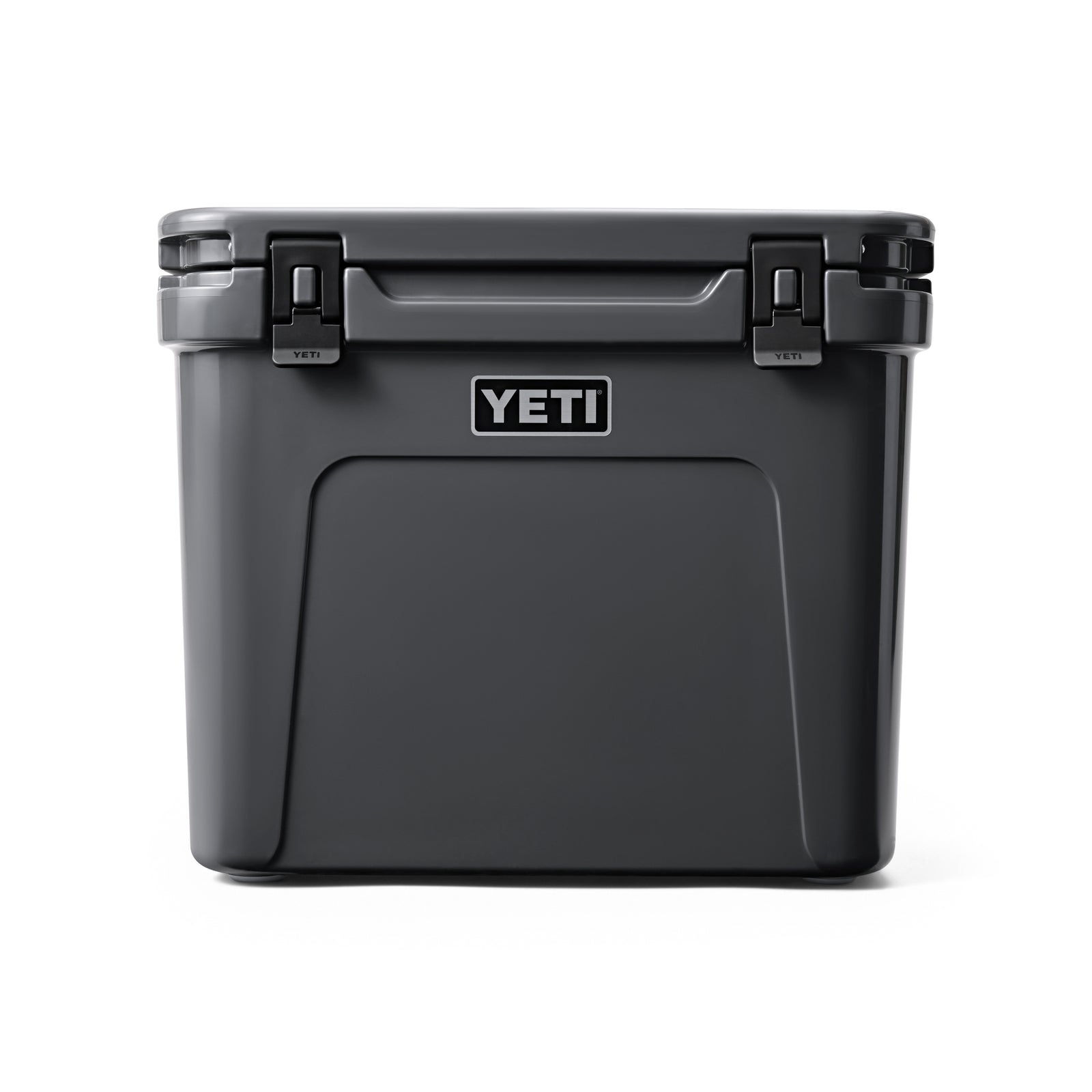 Die YETI® Kühlbox Roadie 60 - Charcoal zeichnet sich durch ein rechteckiges Design, robuste schwarze Verschlüsse und einen markanten YETI-Schriftzug auf der Vorderseite aus, der sich von einem schlichten weißen Hintergrund abhebt.