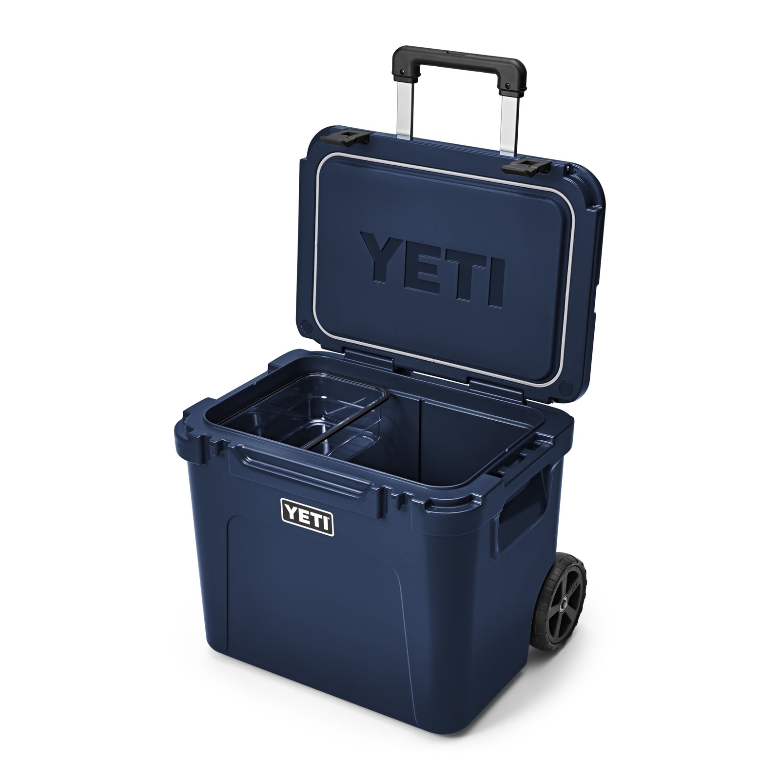 Eine YETI® Kühlbox Roadie 60 - Navy von YETI ist geöffnet und offenbart ihren geräumigen Innenraum mit Trennwand. Das YETI-Logo erscheint auf dem Deckel und der Vorderseite dieser hochwertigen Camping-Kühlbox mit Rollen.