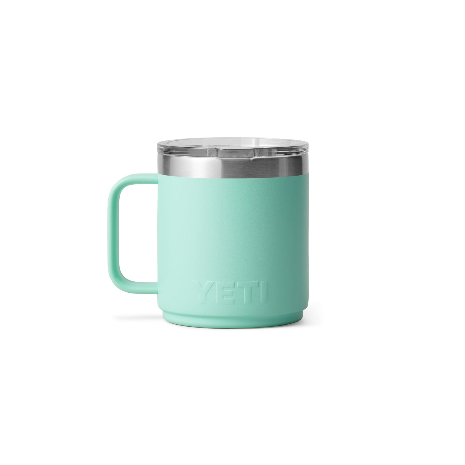 Eine YETI® Tasse Rambler 10 Oz in Seafoam, mit Griff und durchsichtigem Deckel, zeigt das eingeprägte YETI-Logo in der Nähe des Bodens. Seine doppelwandige Vakuumisolierung hält Getränke heiß oder kalt. Der Becher ist vor einem weißen Hintergrund zentriert.