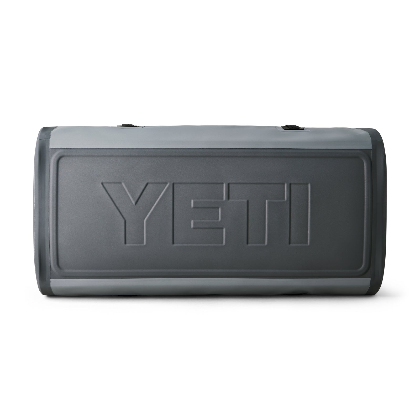 Eine YETI® Reisetasche Panga 100 in Storm Grey liegt auf der Seite, das markante YETI-Logo ist sichtbar. Diese wasserdichte Tasche wirkt einfach, ohne Reißverschlüsse oder Griffe aus diesem Blickwinkel.