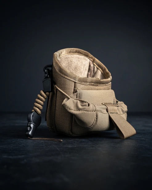 Eine EBERLESTOCK Mag-Free Rangefinder Pouch in Hellbraun mit Taschen und einem Seitenclip ist aufrecht auf einer dunklen Fläche mit dunklem Hintergrund abgebildet.
