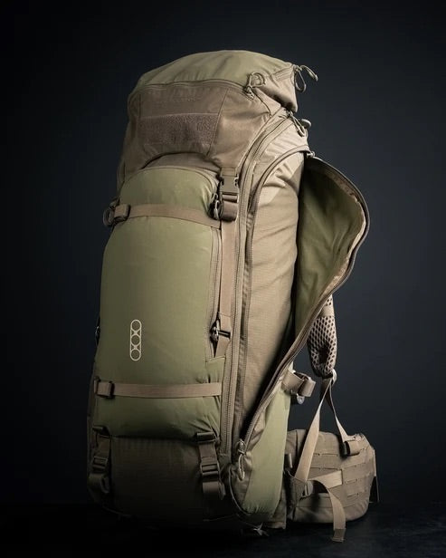 Der EBERLESTOCK Brute 4500 ist ein großer, olivgrüner Wanderrucksack mit mehreren Fächern, Gurten und Polstern. Er steht aufrecht vor einem dunklen Hintergrund, wobei eine Seite des Hauptfachs offen und ohne Reißverschluss ist.