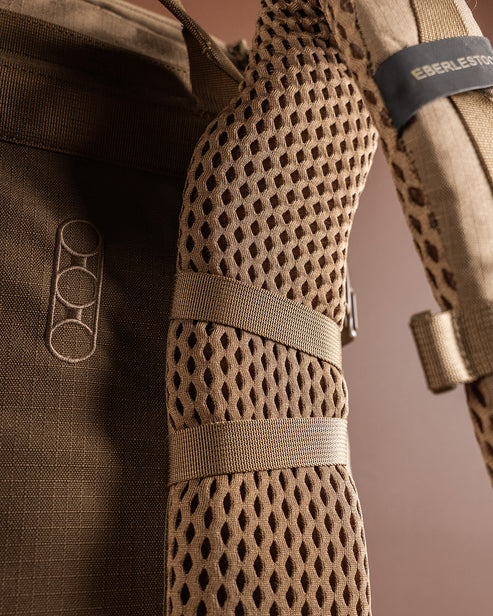 Nahaufnahme eines braunen EBERLESTOCK Brute 3500 Gurtes mit atmungsaktiver Mesh-Polsterung, horizontalen Schlaufen und einem aufgestickten Markenlogo - perfekt für jedes Outdoor-Abenteuer.