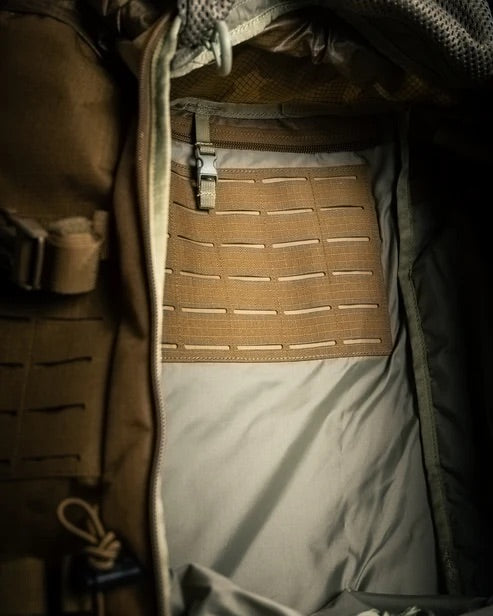 Nahaufnahme des hautfarbenen Eberlestock Mission Ruck von EBERLESTOCK, der mit einem MOLLE-Element mit horizontalen Schlitzen und einem Clip für modulare Befestigungen und organisierte Ausrüstung ausgestattet ist - perfekt für jede einsatzbereite Ausrüstung.