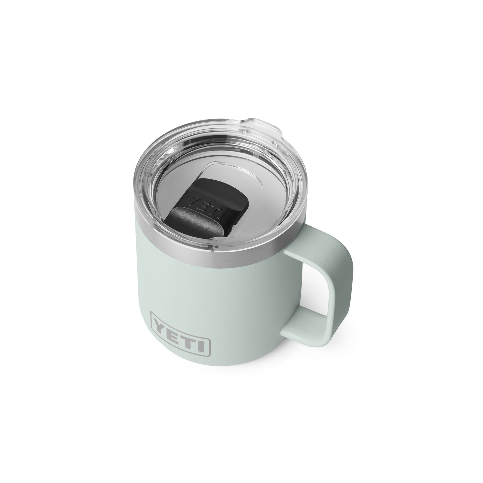 Eine hellgrüne YETI® Tasse Rambler 10 Oz - Ridgeline mit Keramikbeschichtung, großem Griff und klarem Kunststoffdeckel mit schwarzem Schiebedeckel ist auf weißem Hintergrund abgebildet.