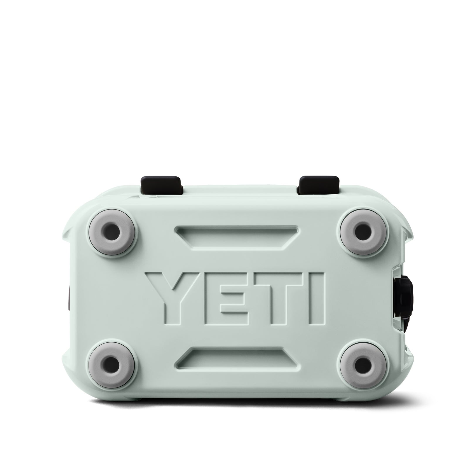 Die YETI® Kühlbox Roadie 15 - Ridgeline ist von vorne abgebildet und verfügt über ein erhabenes YETI-Logo, vier graue Gummifüße, zwei schwarze Deckelverschlüsse und einen schwarzen Seitenverschluss.