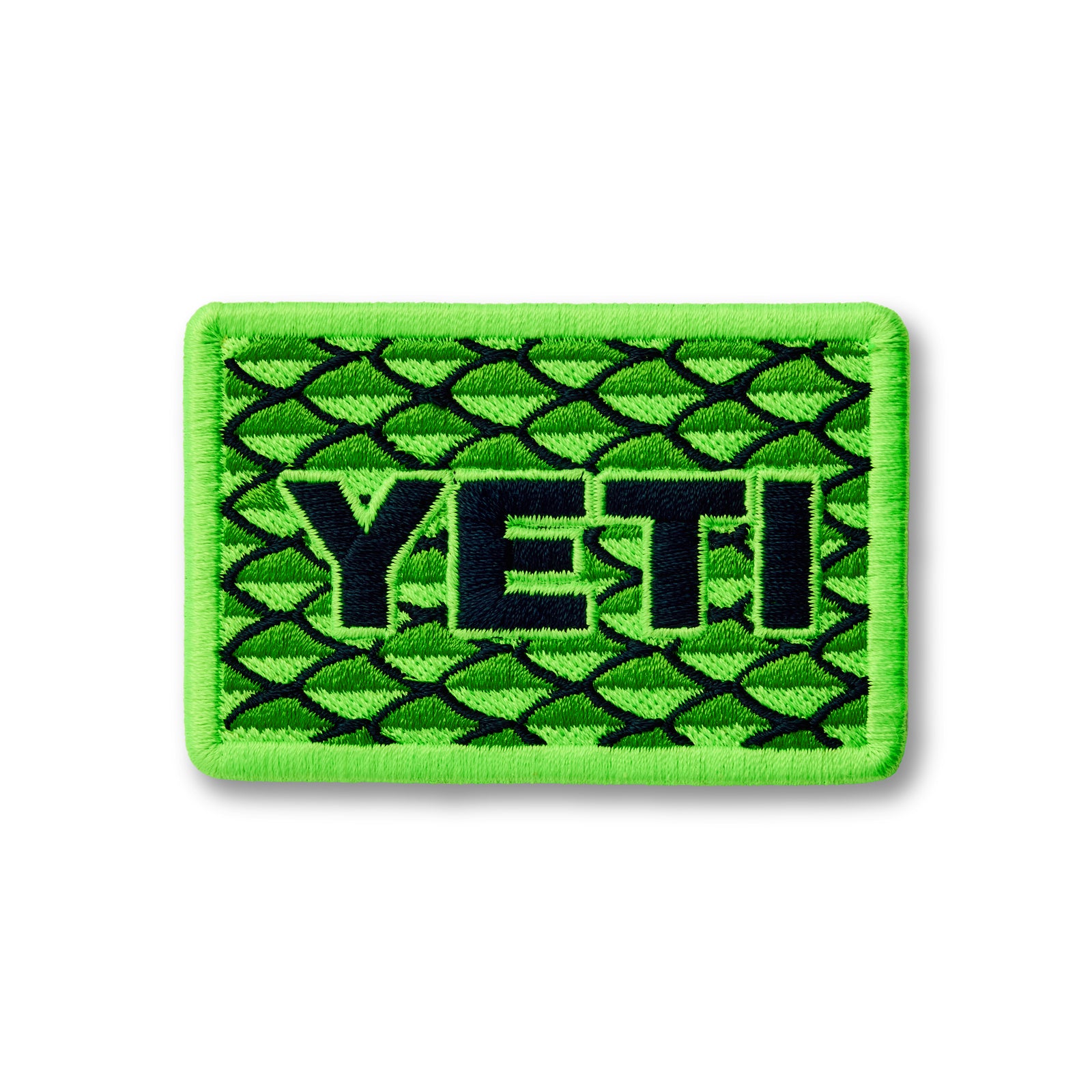 Der YETI® Scales Patch ist ein rechteckiger grüner Aufnäher mit einem Fischschuppenmuster und dem Schriftzug "YETI" - ideal für Ihre Outdoor-Ausrüstung.