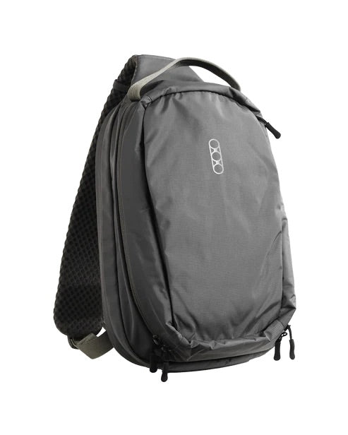 Die EBERLESTOCK Fade Sling ist eine graue Slingtasche mit einem Griff an der Oberseite, Reißverschlussfächern, einem gepolsterten, strukturierten Riemen und einem kleinen weißen, geometrischen Logo - ideal für das diskrete Tragen von Pistolen.