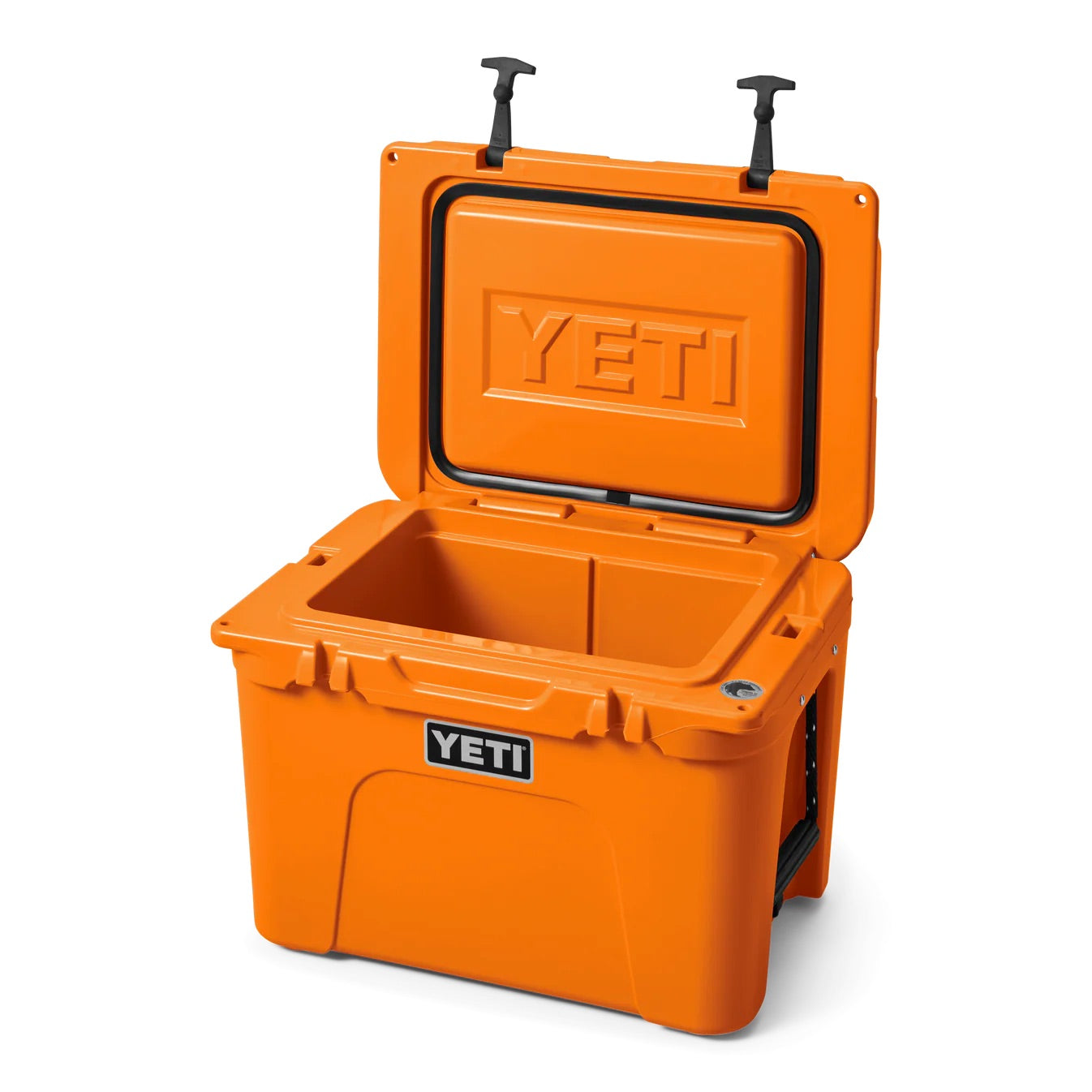 Eine orangefarbene YETI® Kühlbox Tundra 35 - King Crab mit rotationsgeformter Konstruktion sitzt offen und zeigt das YETI-Logo im Deckel. Die Kühlbox verfügt über schwarze Seitengriffe und zwei schwarze Verschlüsse an der Oberseite.