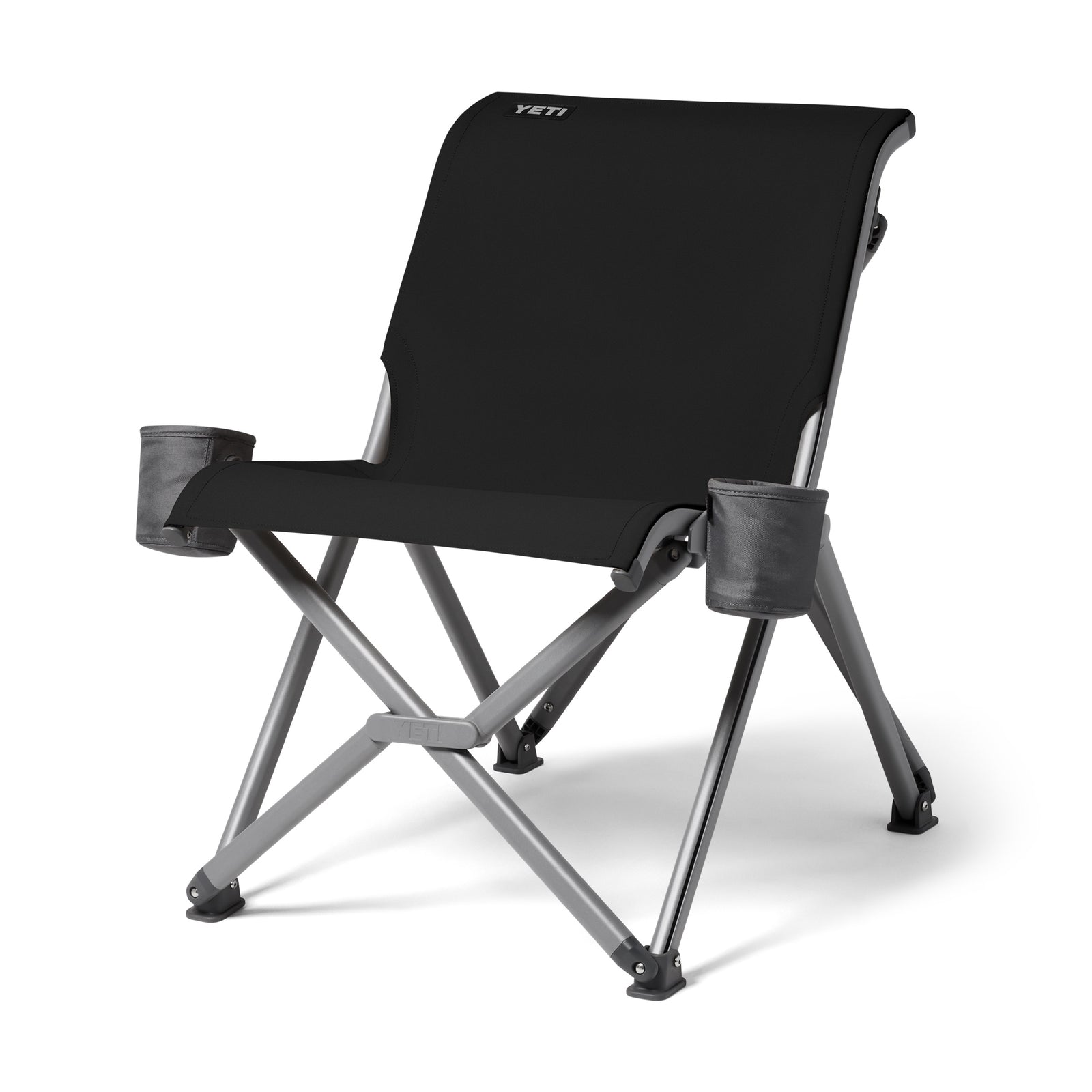 Der YETI® Camping Stuhl Trailhead Field - Black hat graue Metallbeine, eine breite Sitzfläche und Rückenlehne, zwei Becherhalter an den Armlehnen und das YETI-Logo in der oberen linken Ecke der Rückenlehne.