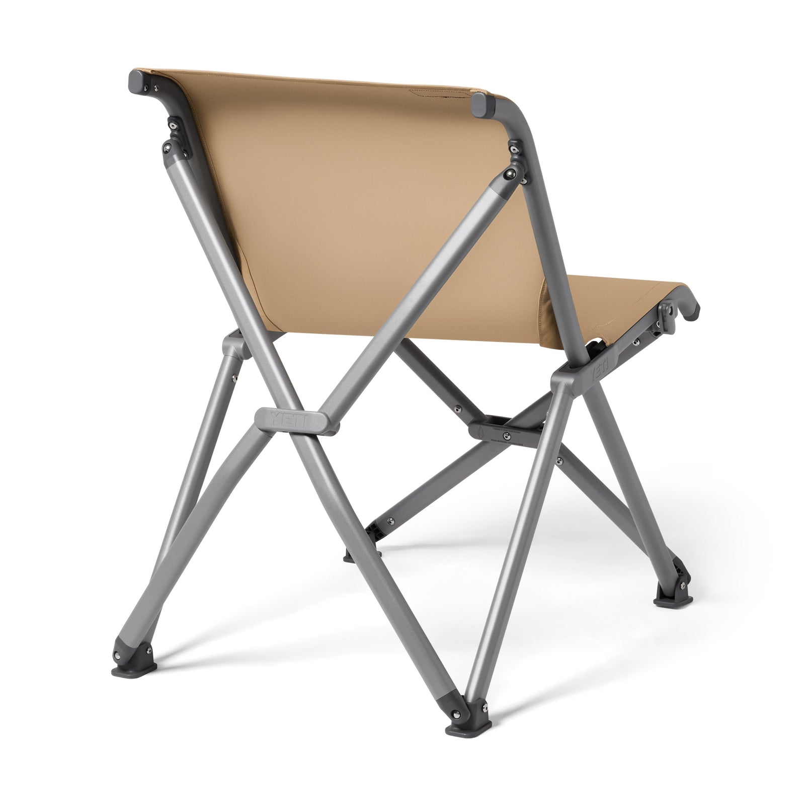 Der YETI® Camping Stuhl Trailhead Field - Tan verfügt über einen Sitz und eine Rückenlehne aus hellbraunem Segeltuch mit einem grauen Metallrahmen, der von schräg hinten auf weißem Hintergrund dargestellt ist.
