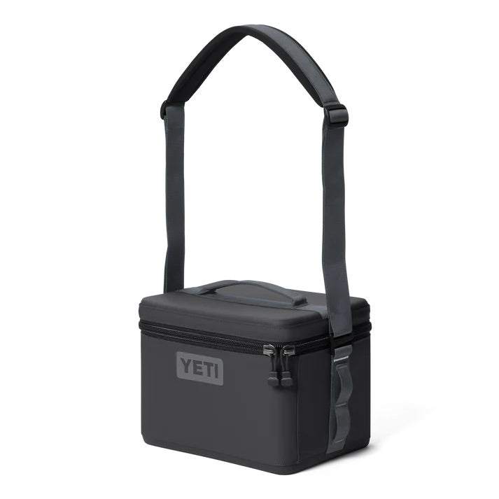 Die YETI® Kühltasche Daytrip 9L in Charcoal hat eine rechteckige Form, einen Reißverschluss oben, eine Reißverschlusstasche vorne, einen stabilen Griff und einen verstellbaren Schultergurt - die ultimative isolierte Lunchbox für jedes Abenteuer.