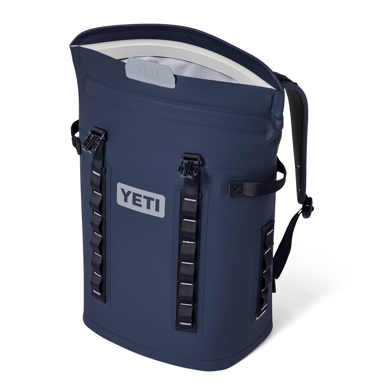 Der YETI® Hopper Backpack M20 in Classic Navy verfügt über eine ColdCell-Isolierung, einen Reißverschluss an der Oberseite, seitliche Griffe, verstellbare Schultergurte und leitergestützte Materialschlaufen an der Vorderseite und den Seiten. Er steht aufrecht und bleibt für einfachen Zugriff teilweise geöffnet.