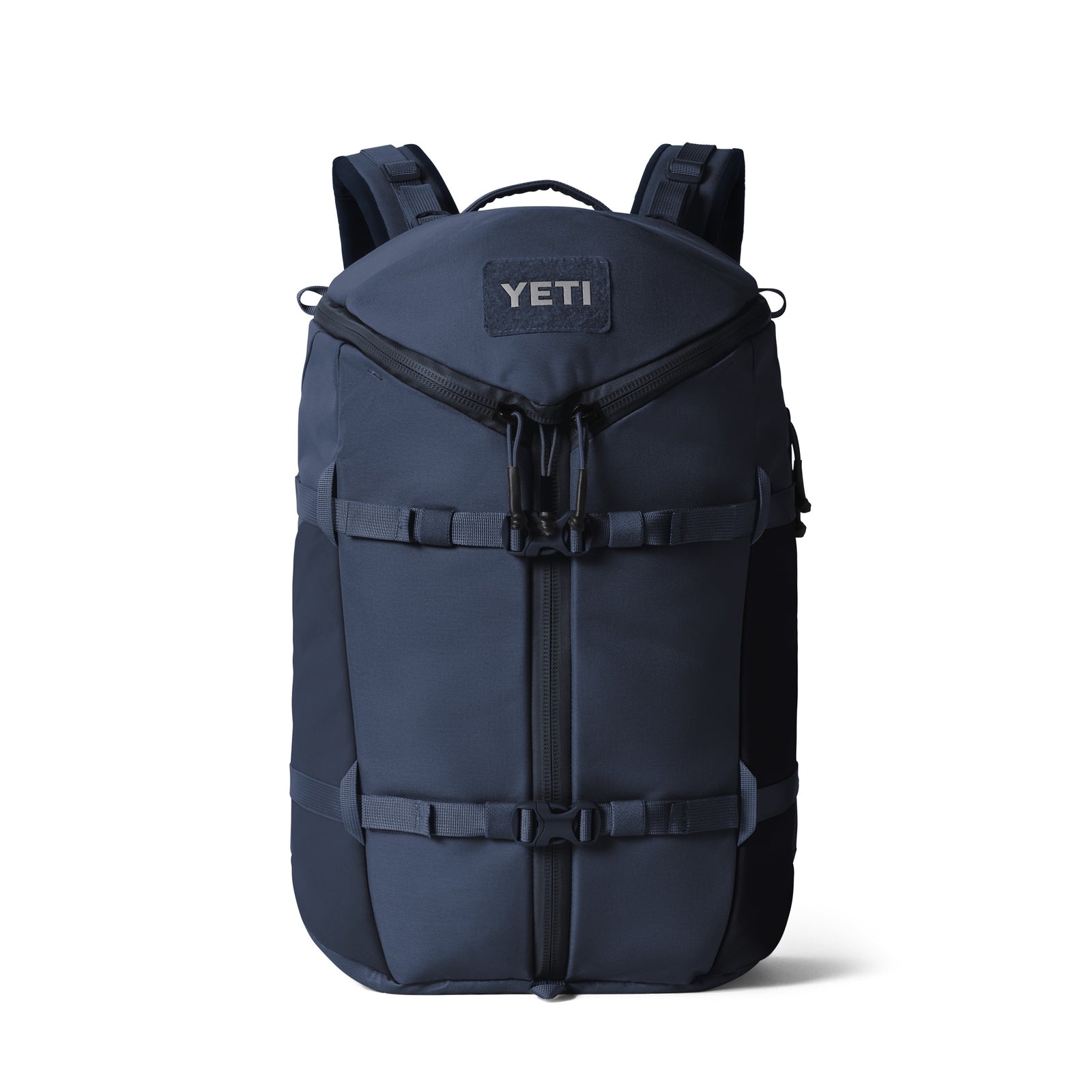 Der YETI® Rucksack Ranchero™ 27L in Classic Navy verfügt über zwei Frontschnallen, gepolsterte Schultergurte, einen Reißverschluss an der Oberseite und ein wasserabweisendes Design. Der YETI Logoaufnäher befindet sich auf der oberen Vorderseite der Tasche.