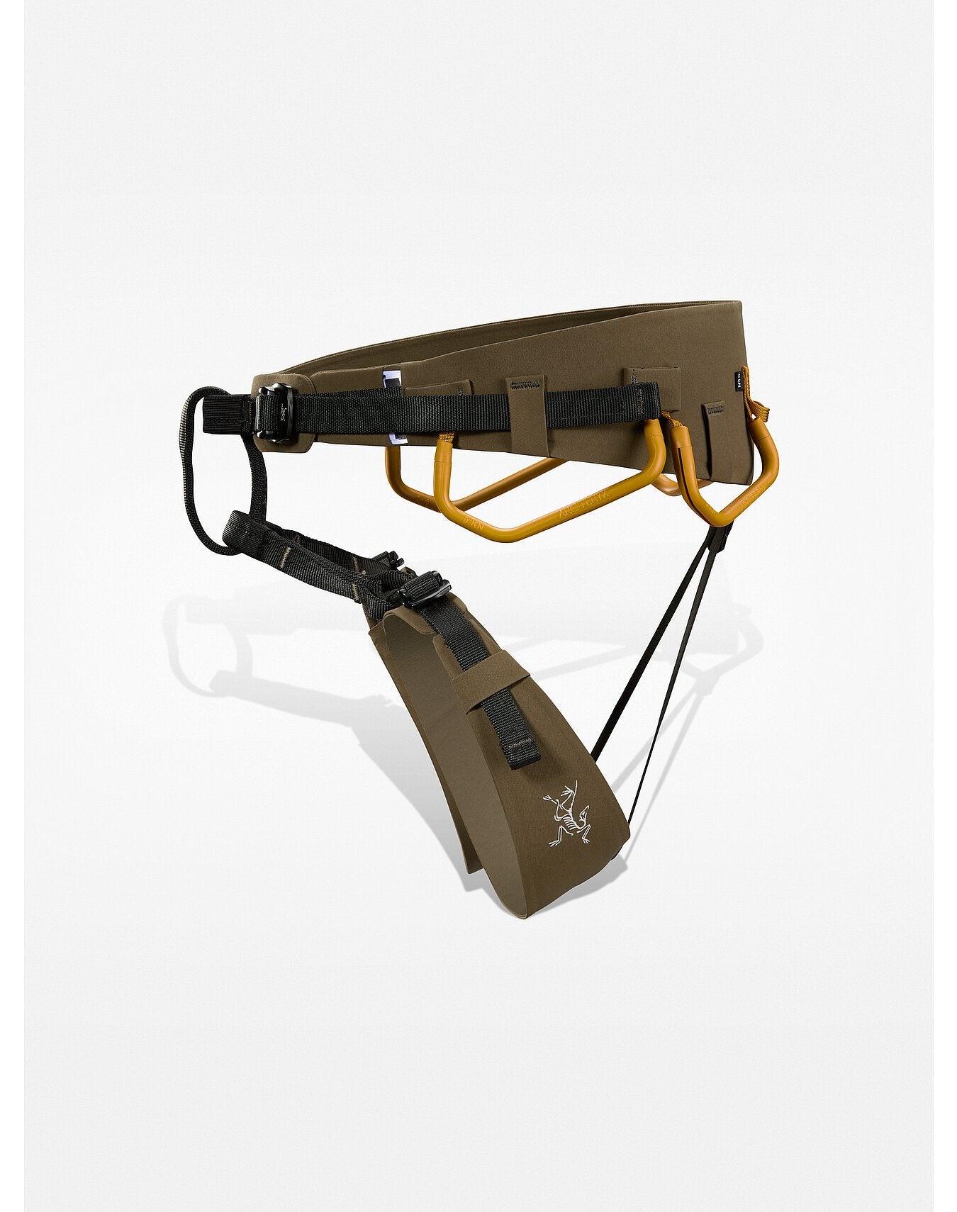 Ein brauner und schwarzer ARC'TERYX LEAF Arc'teryx AR-395a Harness mit goldenen Materialschlaufen, verstellbaren Gurten, Warp Strength Technology und einem weißen Tierlogo auf der Beinschlaufe, dargestellt auf einem schlichten weißen Hintergrund.
