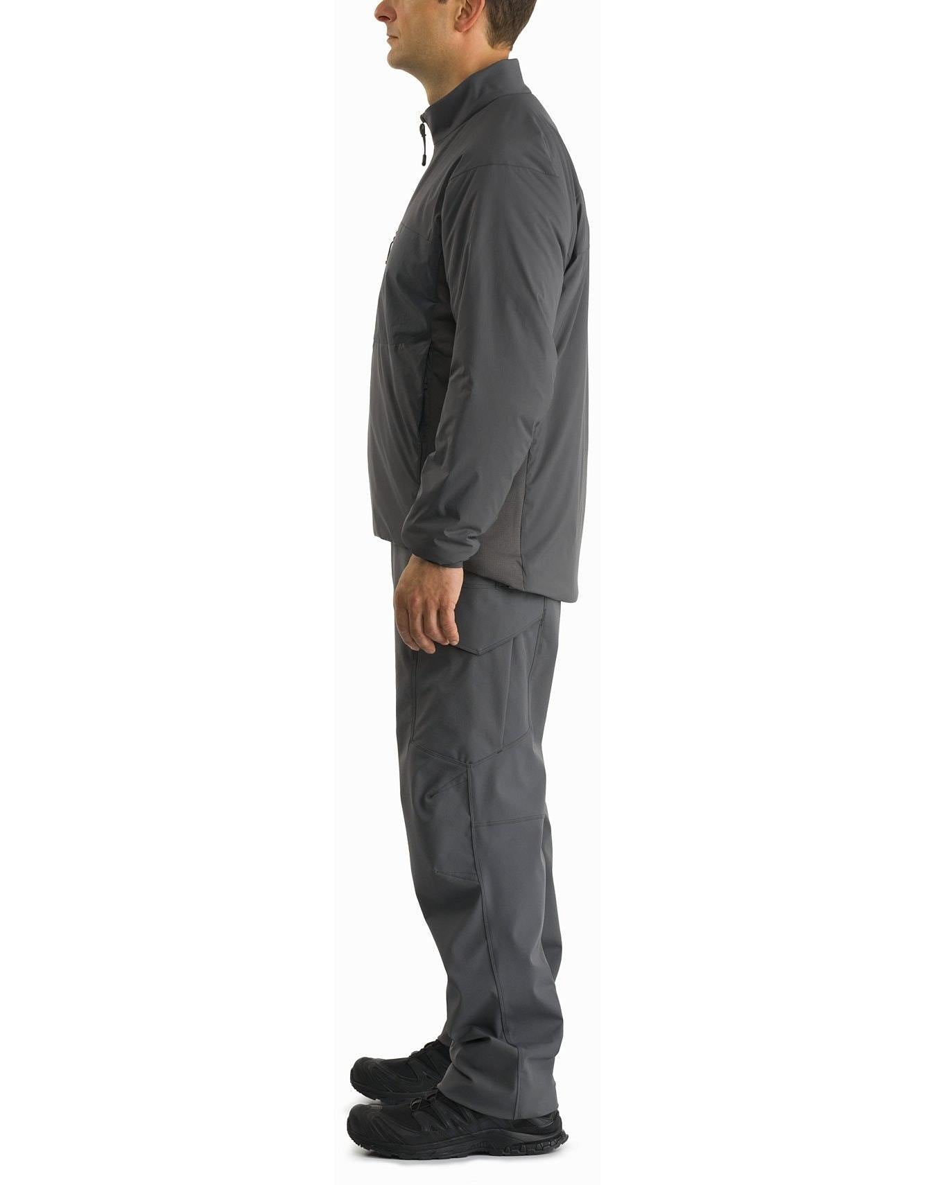 Mann im Profil vor weißem Hintergrund. Trägt eine ARC'TERYX LEAF Arc'teryx Atom Jacket LT Gen2.1 in Ranger Green, gepaart mit einer grauen Hose und schwarzen Sneakers.