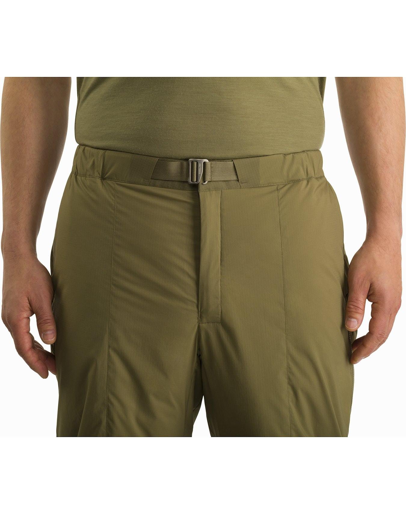 Eine Person, die die Arc'teryx Atom Pant LT Gen2- Crocodile von ARC'TERYX LEAF trägt, von der Taille bis zur Mitte des Oberschenkels, mit den Händen an der Seite vor einem einfarbig weißen Hintergrund.