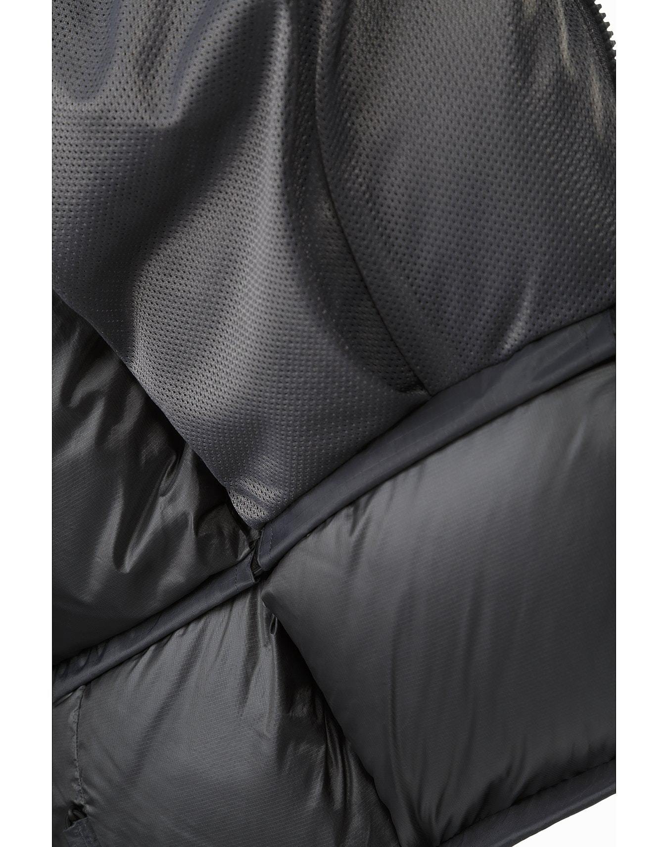 Nahaufnahme des ARC'TERYX LEAF Arc'teryx Cold WX Parka SVX - Wolf. Hervorzuheben ist das strukturierte, perforierte Gewebe im oberen Bereich und das glatte, glänzende Gewebe im unteren Bereich mit sichtbaren Nähten und Absteppungen.