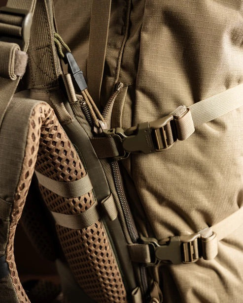 Nahaufnahme eines EBERLESTOCK Brooks 7000 Rucksacks in Military Green mit netzgepolsterten Schulterriemen, Kunststoffschnallen, Reißverschlüssen und robustem Gewebe mit Gurtband - ideal für Trekking- und Jagdabenteuer.