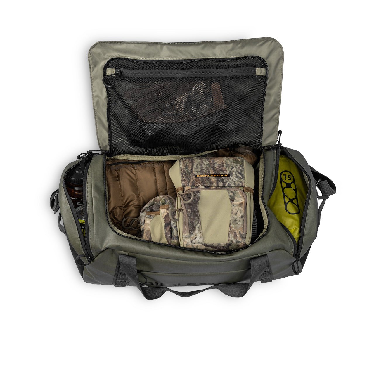Eine geöffnete EBERLESTOCK Hyllus Duffel 65 mit 65 Litern Fassungsvermögen wird von oben betrachtet und zeigt mehrere Fächer, die mit Tarnkleidung, brauner Ausrüstung, Handschuhen in einem Netzfach und einem gelben Gegenstand an der Seite ausgestattet sind.