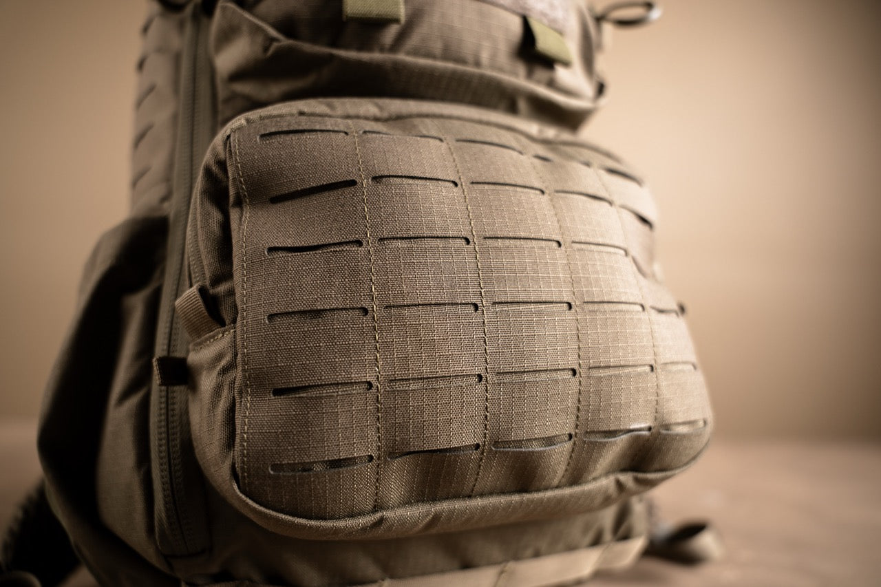 Nahaufnahme des EBERLESTOCK Romad in Schwarz mit lasergeschnittenem MOLLE-Gurtband an der Vordertasche - perfekt zur Befestigung von Ausrüstung. Das robuste Material unterstreicht die Langlebigkeit dieses Rucksacks.
