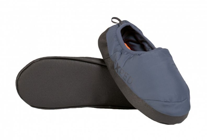 Der EXPED Camp Slipper - Navy ist ein blauer Hausschuh zum Hineinschlüpfen mit einer dicken schwarzen rutschfesten Sohle. Ein Slipper steht aufrecht, während der andere auf der Seite liegt, um die Sohle zu zeigen.