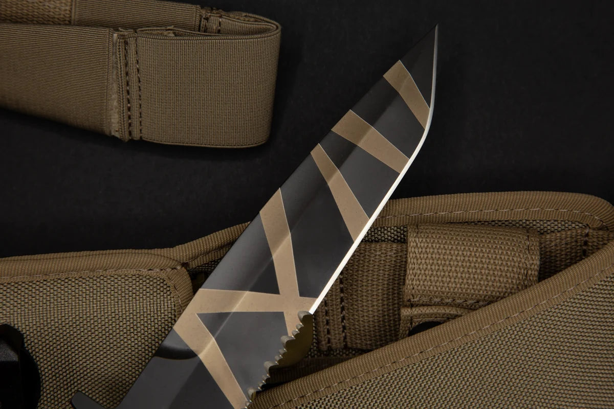 Eine Nahaufnahme des EXTREMA RATIO Messer COL Moschin Desert Warfare Messers mit schwarzer Klinge mit hellbraunen geometrischen Mustern und partiellem Wellenschliff, das auf hellbraunen Riemen und Scheide vor einem schwarzen Hintergrund ruht.