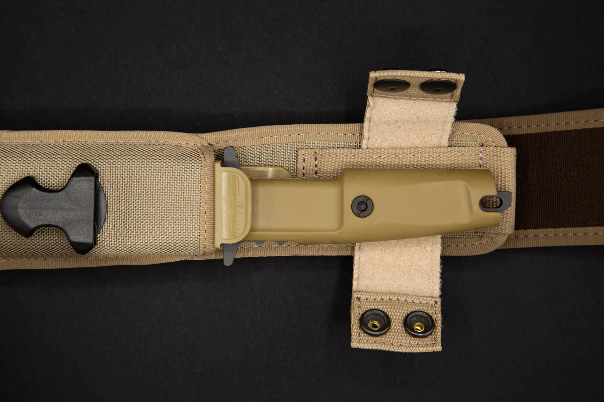 In einer hellbraunen taktischen Scheide steckt das EXTREMA RATIO Extrema Ratio Messer COL Moschin Desert Warfare, dessen schwarze Klinge teilweise sichtbar ist und das an einem beigen Gürtel mit Schnappverschlüssen befestigt ist, alles vor einem dunklen Hintergrund.