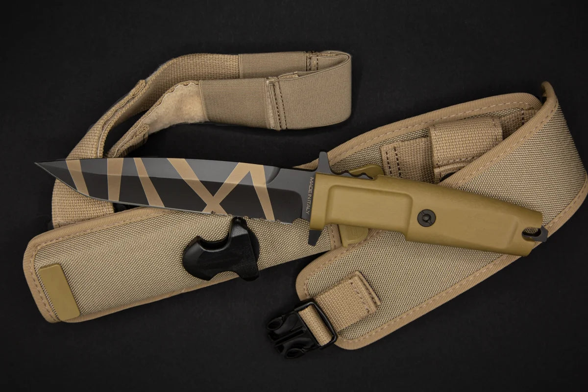 Das EXTREMA RATIO Extrema Ratio Messer COL Moschin Desert Warfare verfügt über einen hellbraunen Griff und eine geometrisch gemusterte Klinge, die auf einer passenden hellbraunen Scheide mit Riemen und schwarzer Schnalle ruht, alles vor einem dunklen Hintergrund.