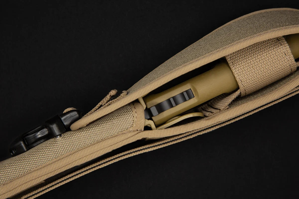 Eine Nahaufnahme eines EXTREMA RATIO Extrema Ratio Messer COL Moschin Desert Warfare, das teilweise aus seinem braunen taktischen Etui herausgenommen wurde, zeigt einen Teil des Messers vor einem schwarzen Hintergrund.