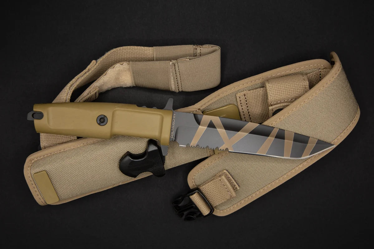 Das EXTREMA RATIO Extrema Ratio Messer COL Moschin Desert Warfare Messer mit hellbraunem Griff und gestreifter Klinge ruht auf einer passenden hellbraunen Scheide mit Riemen auf schwarzem Hintergrund.