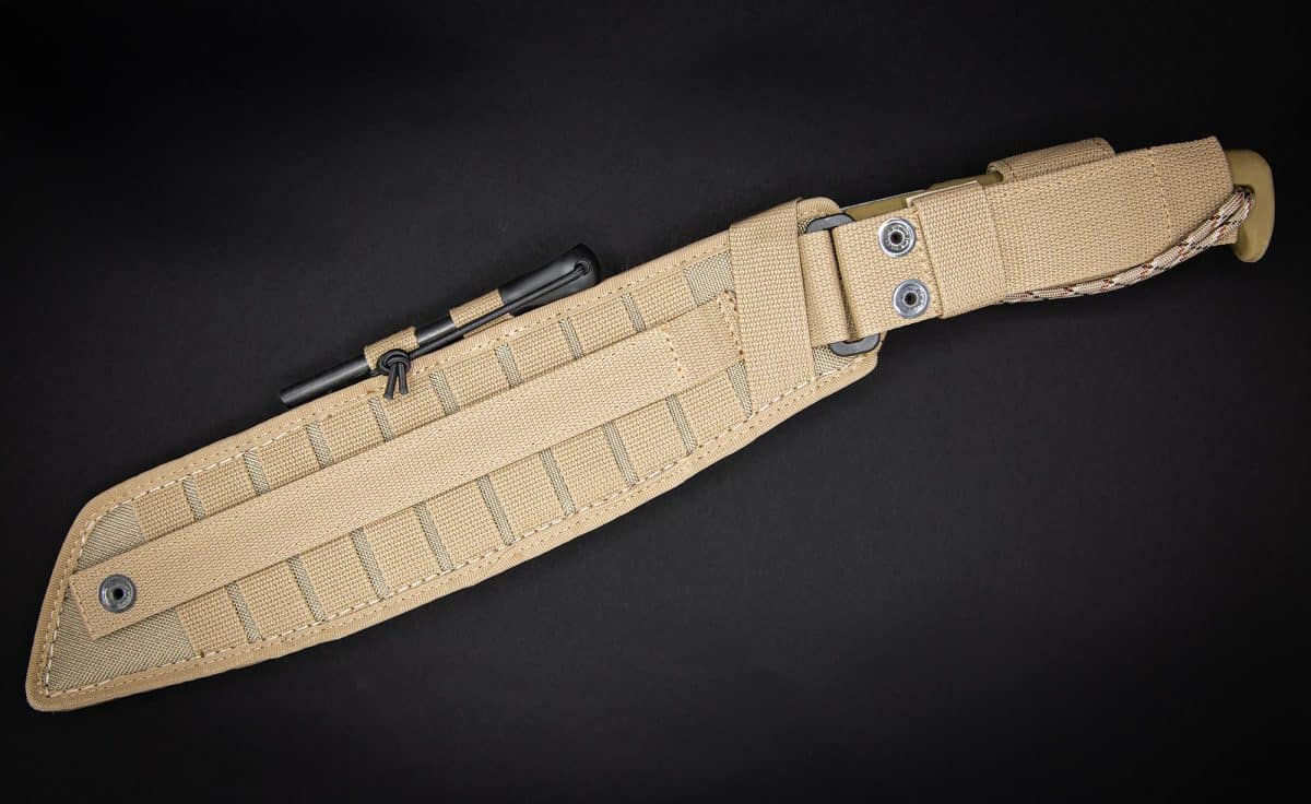 Eine hellbraune Scheide mit horizontalem Gurtband, Befestigungsriemen und einem kleinen schwarzen Stift an der Seite für die EXTREMA RATIO Messer Kreios Expedition Machete von EXTREMA RATIO, dargestellt auf einem schwarzen Hintergrund.