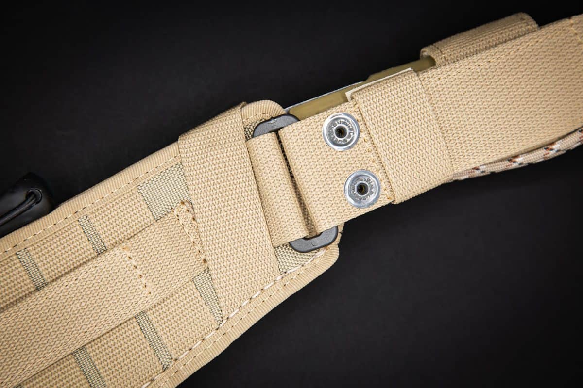 Nahaufnahme eines hellbraunen taktischen Gürtels mit verstärkten Nähten, Metallösen und MOLLE-Gurtband auf schwarzem Hintergrund - perfekt für das Tragen der EXTREMA RATIO Extrema Ratio Messer Kreios Expedition oder einer Outdoor-Machete.