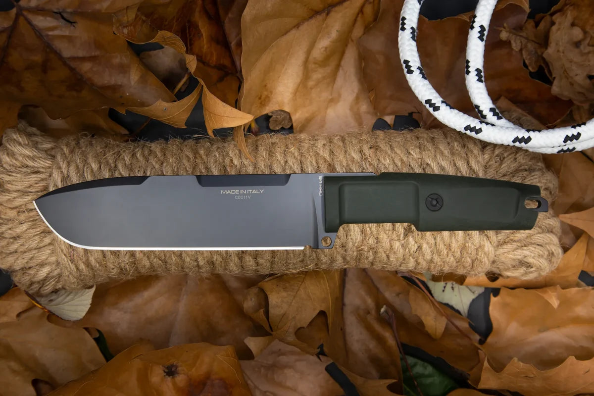 Ein EXTREMA RATIO Extrema Ratio Messer Ontos II S600 Black mit dunklem Griff und großer silberner Klinge ruht auf einem aufgerollten Seil zwischen braunen Herbstblättern und einem weiß-schwarzen Seil.