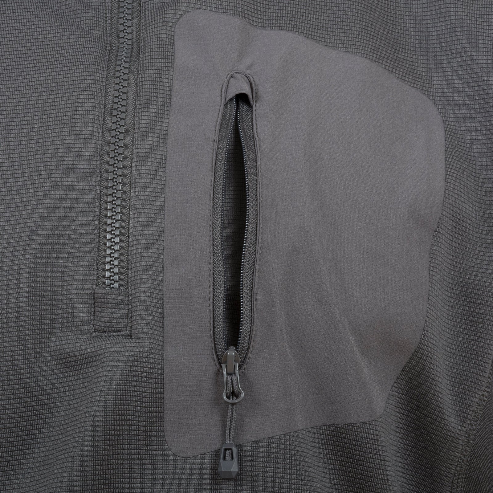 Nahaufnahme des HIGHLANDER FORCES Highlander Forces Tactical Hirta Fleece in Dunkelgrau, mit einer vertikalen Brusttasche mit Reißverschluss, einem teilweisen horizontalen Reißverschluss auf der linken Seite und einem Material mit Gitterstruktur für einen modernen taktischen Look.