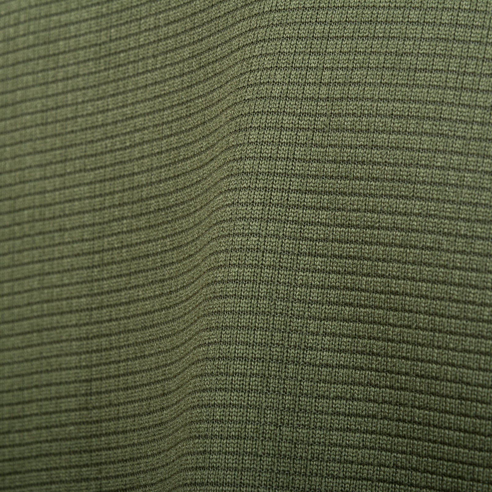 Nahaufnahme des olivgrünen, gerippten Stoffes aus dem Highlander Forces Tactical Hirta Fleece von HIGHLANDER FORCES. Man erkennt die dezent gewellte Textur mit feinen vertikalen und horizontalen Linien, die ein gitterartiges Muster bilden.