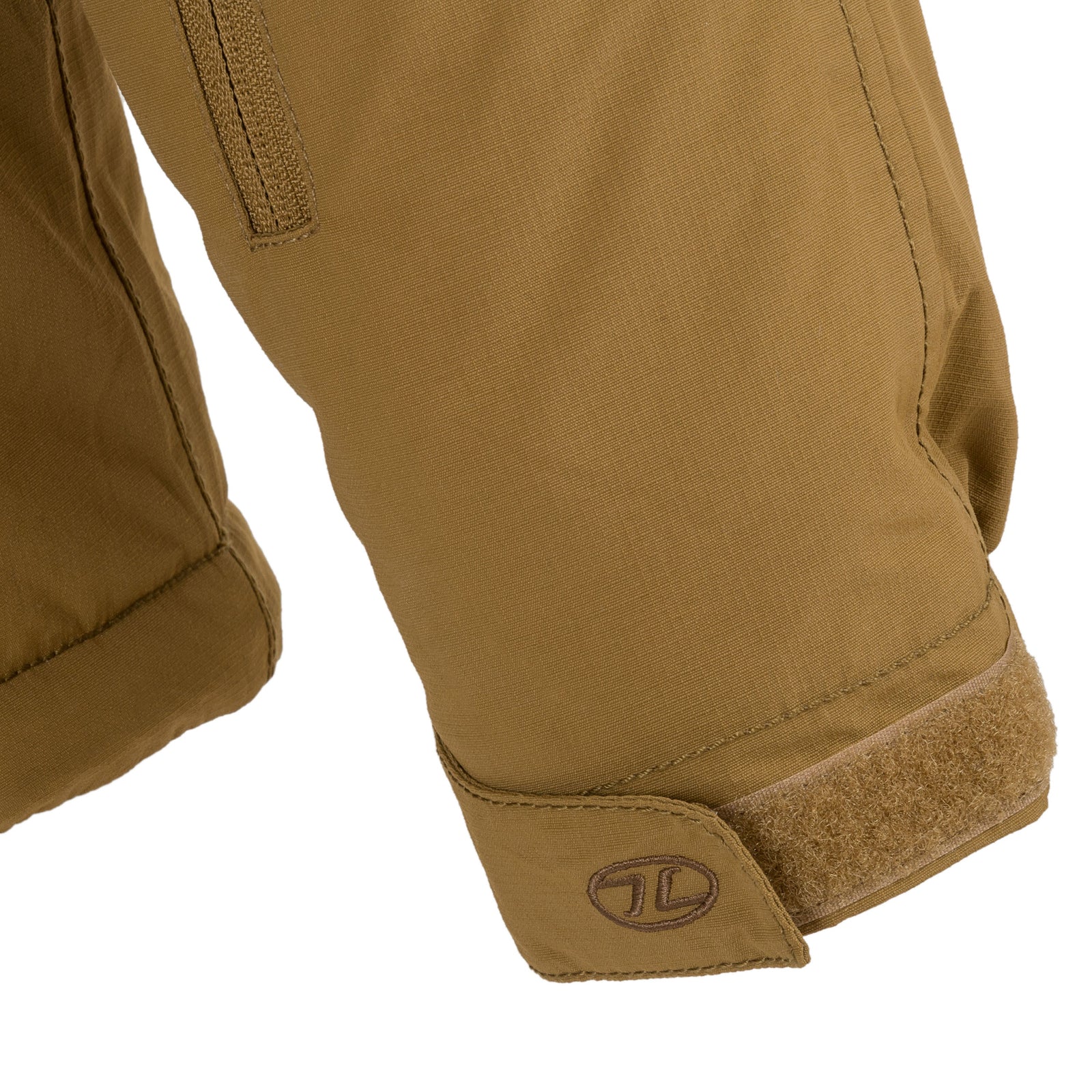 Nahaufnahme eines Ärmels der Highlander Forces Stryker Waterproof Winter Jacket - Ranger Green mit einem Klettverschluss an der Manschette und einem kleinen gestickten Logo in der Nähe des Riemens.