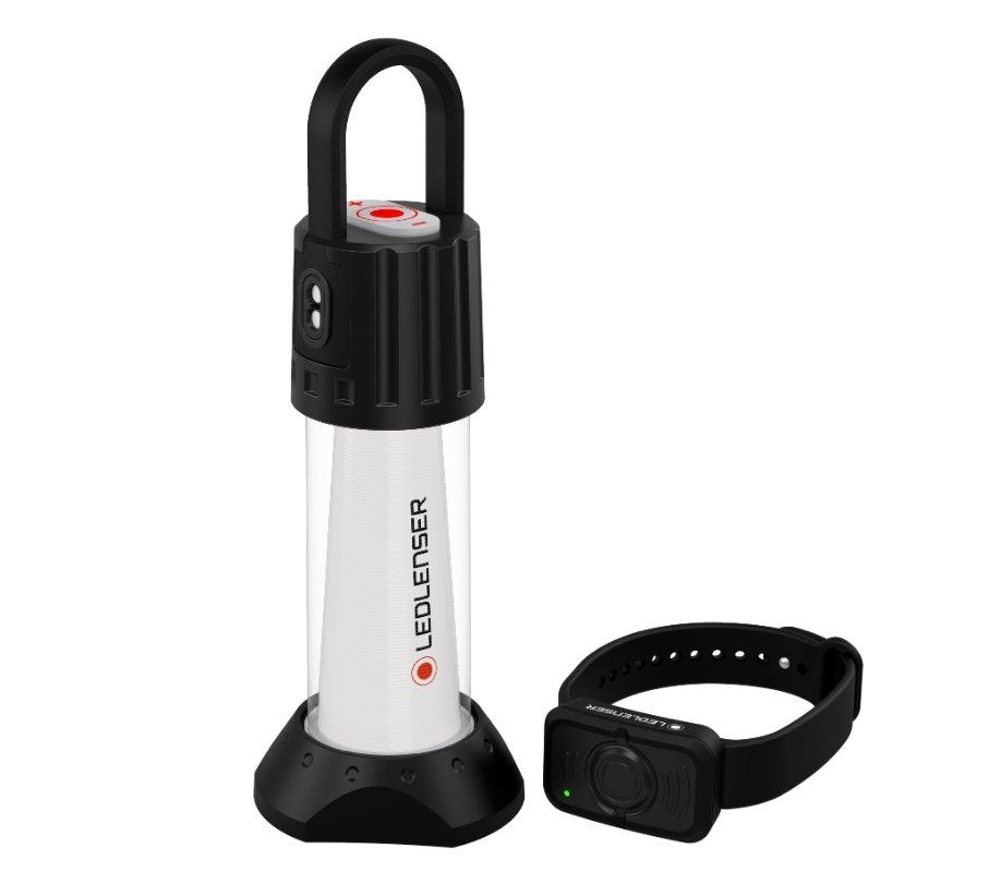 Die LEDLENSER Campinglampe ML6 Connect WL hat einen schwarzen Griff und Sockel, ein silbernes Gehäuse und eine passende schwarze Fernbedienung am Handgelenk auf weißem Hintergrund. Sie bietet warmweißes Licht, perfekt für jedes Outdoor-Abenteuer.