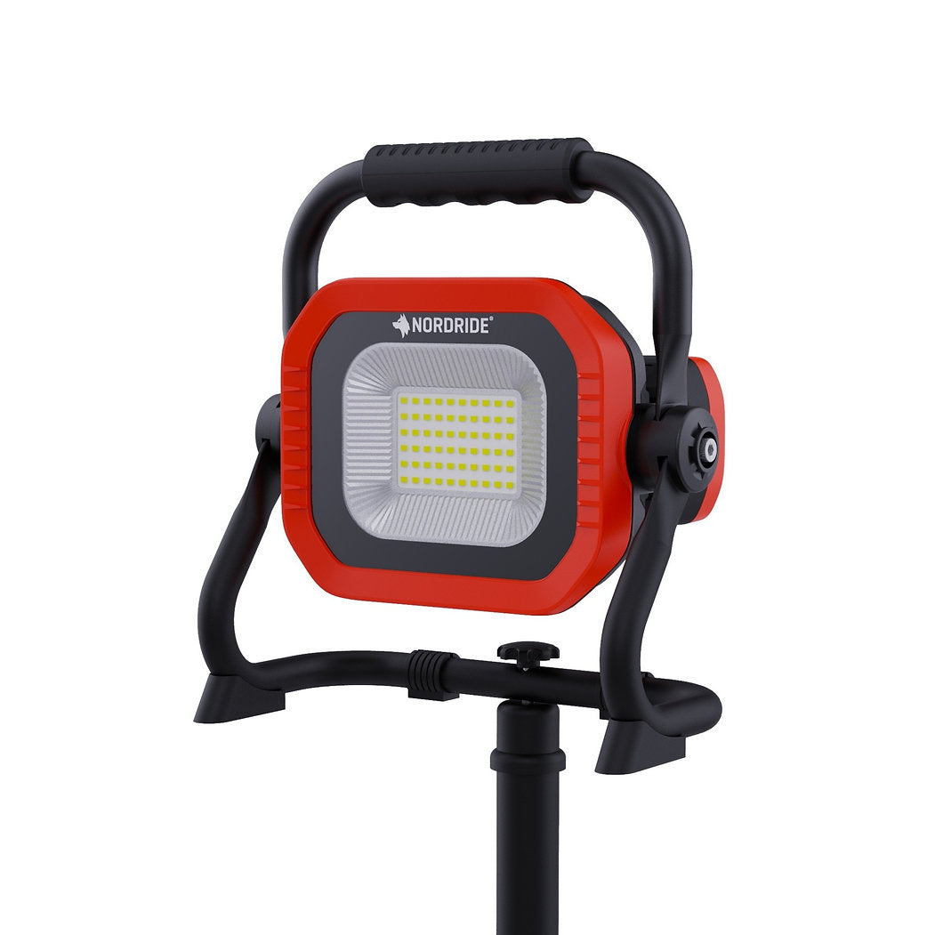 Der Nordride Arbeitsstrahler Sector 50W R ist ein tragbarer, batteriebetriebener LED-Arbeitsscheinwerfer mit einem rot-schwarzen Gehäuse, einem verstellbaren schwarzen Ständer, einem oberen Griff und dem NORDRIDE-Logo über dem Panel - perfekt für Baustellen.