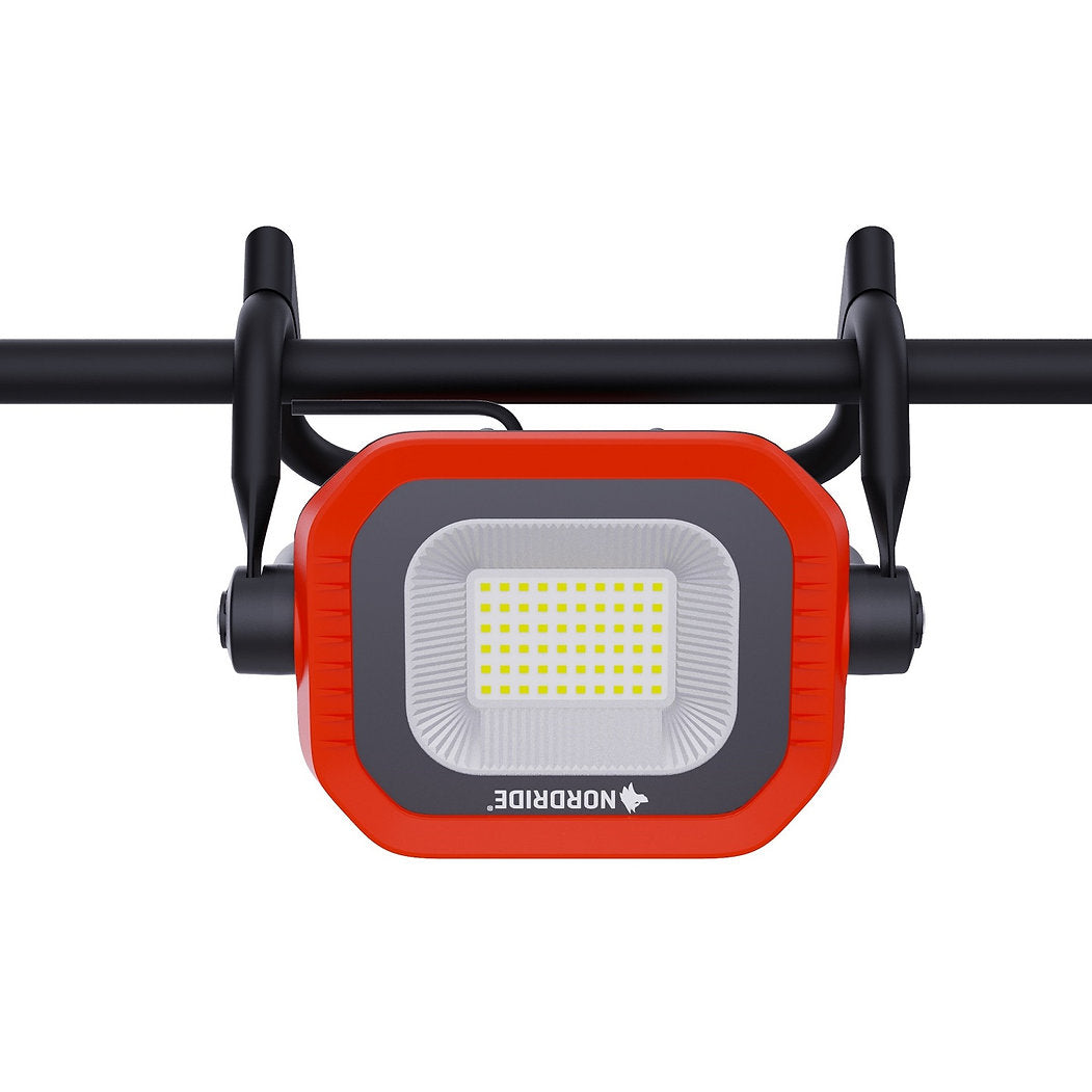 Der Nordride Arbeitsstrahler Sector 60W 4000K, ein rechteckiger, rot-schwarzer, tragbarer LED-Arbeitsscheinwerfer von NORDRIDE, wird mit zwei Halterungen an einer schwarzen Stange befestigt und verfügt über ein Gitter aus gelben LEDs, wodurch er sich ideal als 60W-Flutlicht für verschiedene Aufgaben eignet.