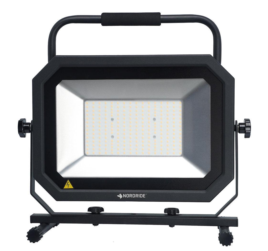 Der Nordride Baustrahler Sector 150W IP65 ist ein schwarzer, rechteckiger LED-Arbeitsscheinwerfer mit einem Griff, einem verstellbaren Ständer und mehreren LEDs, die auf der Vorderseite den Schriftzug NORDRIDE tragen - ideal für anspruchsvolle Bedingungen dank der robusten Schutzart IP65.