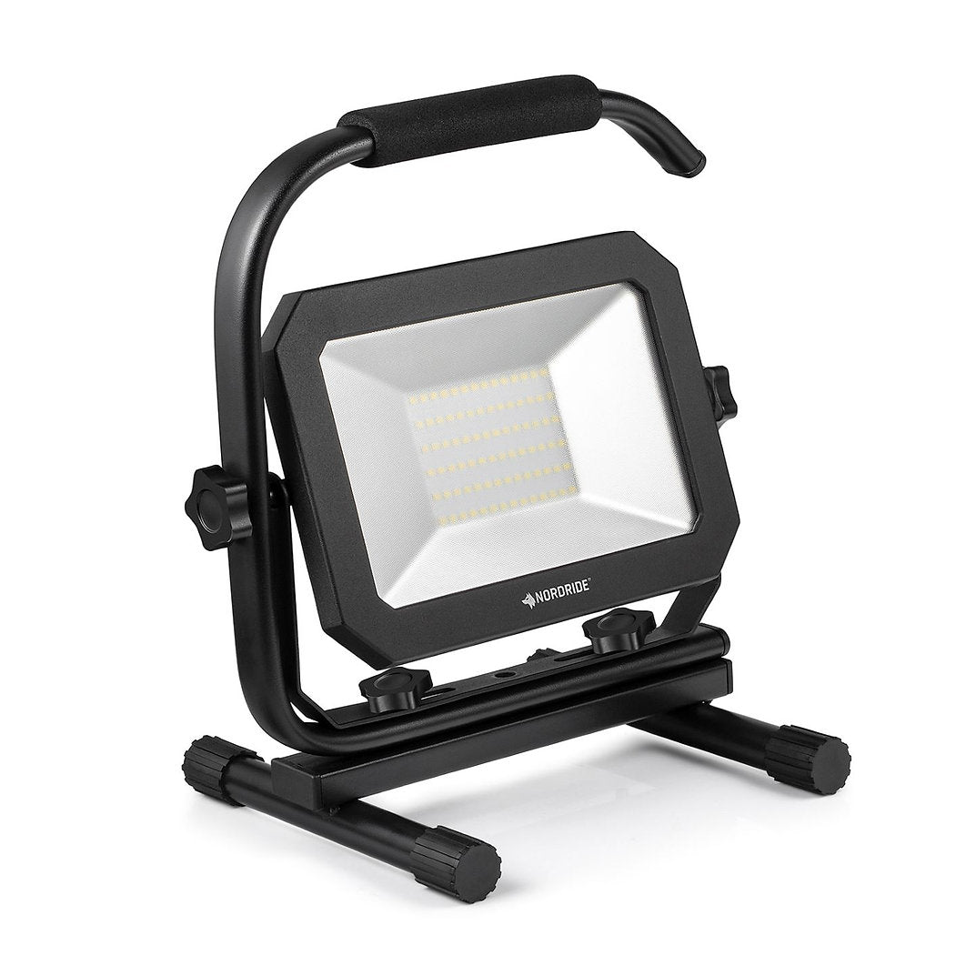 Der NORDRIDE Nordride Baustrahler Sector 50W IP65 ist eine tragbare LED-Arbeitsleuchte mit schwarzem Rahmen und Griff, stabilem Standfuß mit verstellbaren Knöpfen, rechteckigem Design, LED-Gitter an der Vorderseite und Schutzart IP65 für den Außeneinsatz.