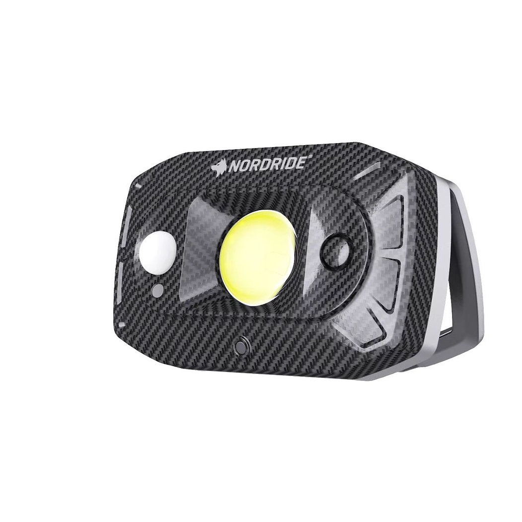 Der Nordride Flutlichtstrahler Guard von NORDRIDE ist ein kompakter, rechteckiger, wiederaufladbarer Flutlichtstrahler mit Kohlefaserstruktur, IP67-Schutz, modernem Sicherheitsdesign und gelbem Rundlicht in der Mitte.