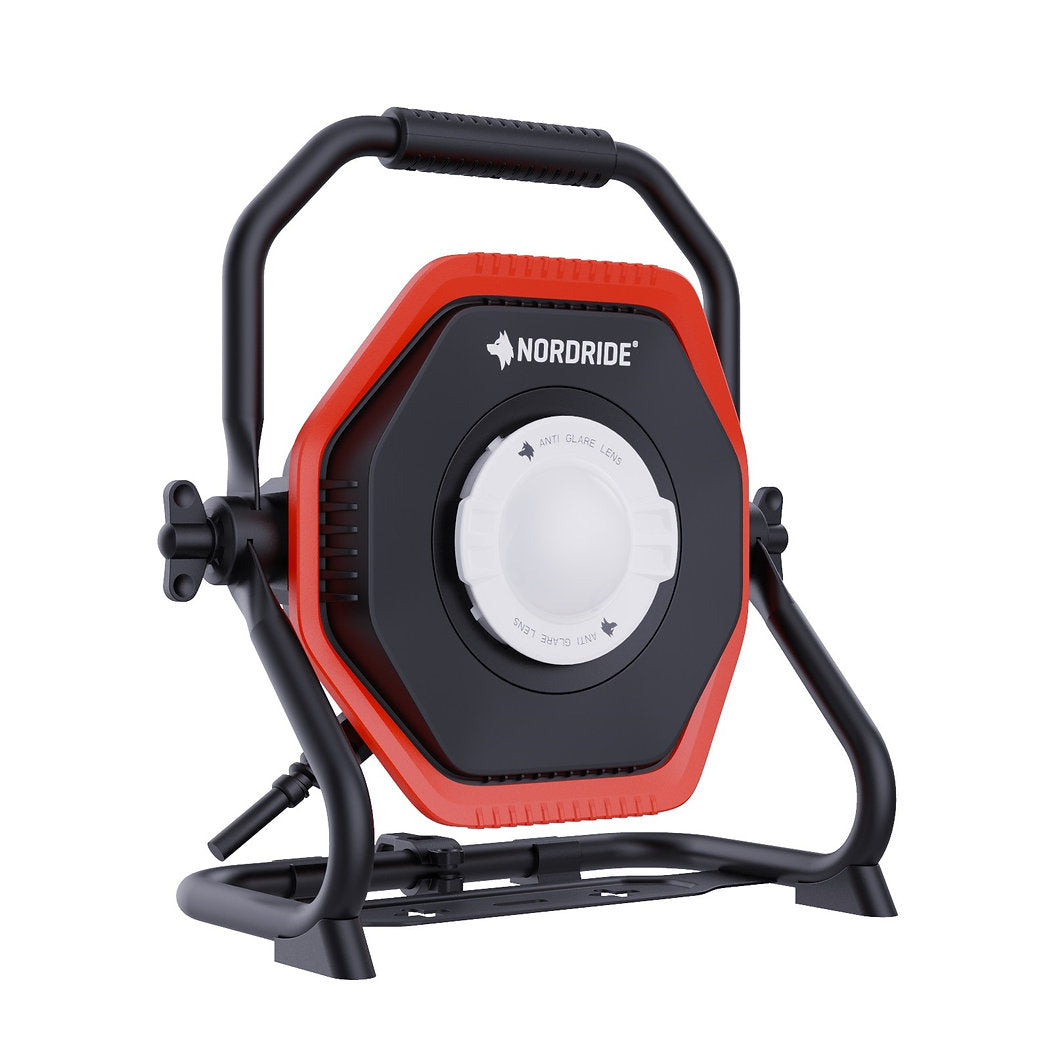 Der NORDRIDE Hochleistungsstrahler Lumos 100 W ist ein tragbarer Arbeitsscheinwerfer mit schwarzem Griff und Gestell, rotem und schwarzem sechseckigen Körper, zentralem weißen Rundlicht und 10.000 Lumen auf einem stabilen, verstellbaren Ständer.